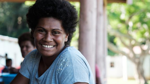 Fijian woman smiling turned towards the camera.