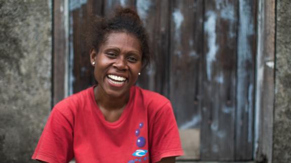 Vanuatu woman wearing a red t-shirt smiling at the camera